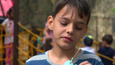 Chico-joven-comiendo-en-zona-juegos