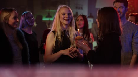 attractive-blond-girl-in-club-receives-congratulations-from-friends