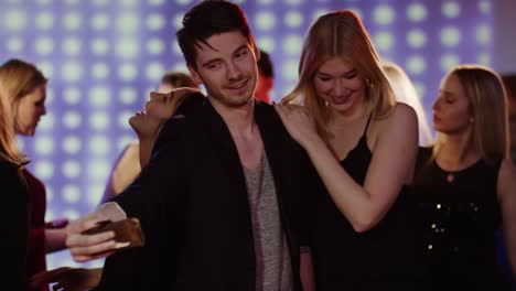 guy-taking-a-selfie-with-two-girls-on-dancefloor-at-club