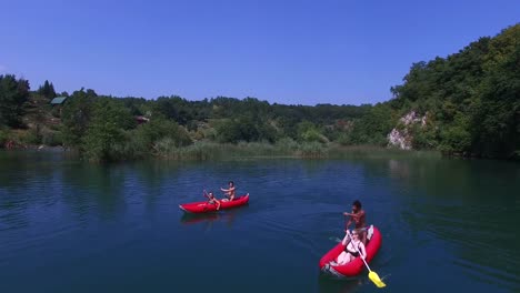 Aerial-view-of-friends-paddling-canoe-on-river