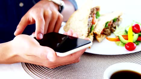 Mann-in-Mittagessen-Bar-mit-Smartphone-und-Kaffee