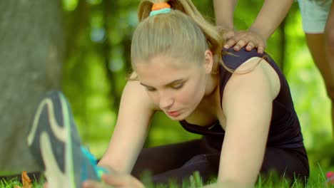 Frau,-dehnen-im-Freien.-Sportliche-Mädchen-Hilfe-dazu-stretching-Übungen