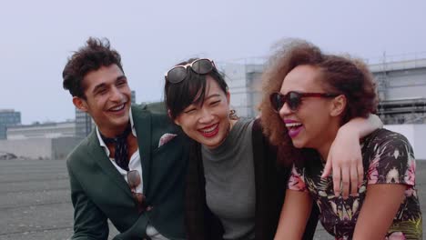 Three-young-friends-sitting-in-terrace-at-evening