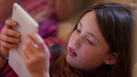 Close-up-of-a-young-teen-using-a-tablet-at-home-with-her-friend