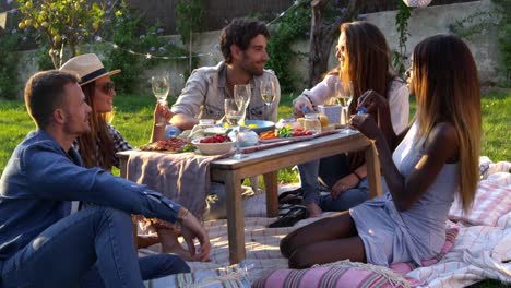 Freunde,-die-Seifenblasen-beim-Picknick-im-Garten