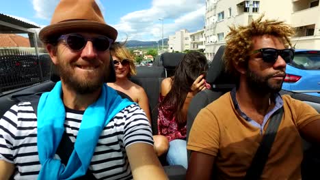 Vier-junge-Freunde,-die-Spaß-im-Cabrio-fahren