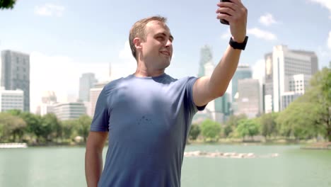 Male-runner-jogging-in-park.-Fit-male-sport-fitness-training.-Making-selfie-on-his-smartphone