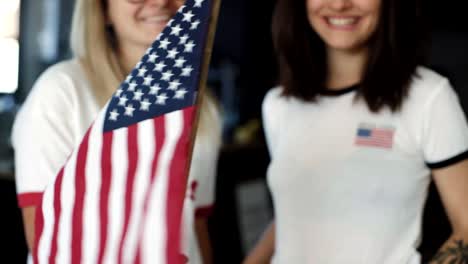 Chicas-rubia-y-morena-hipster-sostener-una-bandera