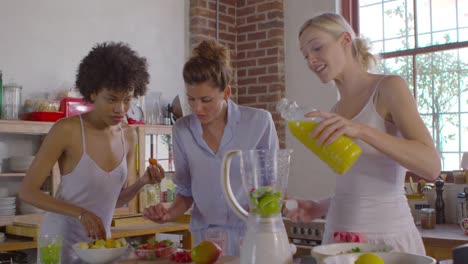 Tres-amigas-haciendo-batidos-juntos-en-la-cocina,-disparos-a-R3D