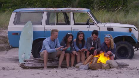 Freunde-am-Strand-hängen-draußen-am-Lagerfeuer