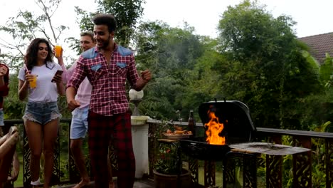 Jóvenes-bailando-reunión-alegre-grupo-de-amigos-de-barbacoa-en-terraza-de-verano-fiesta-de-cocina