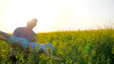 Joyful-boy-at-hands-parent-in-form-of-airplane-at-field,-daddy-with-son-at-arms-played-into-meadow-flowers