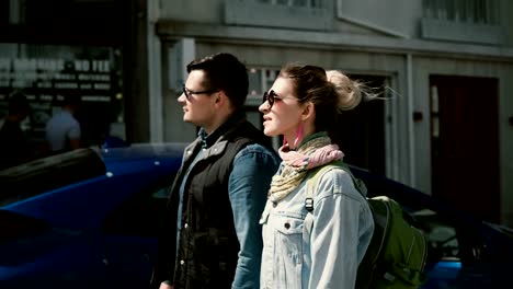 Young-beautiful-couple-walking-in-the-Reykjavik,-Iceland-and-looking-around.-Man-and-woman-near-Hallgrimskirkja-church