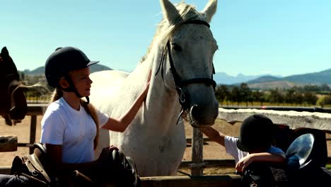 Siblings-touching-the-white-horse-in-the-ranch-4k