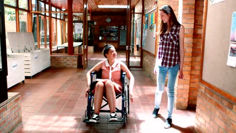 School-girl-interacting-with-her-disabled-friend-in-corridor