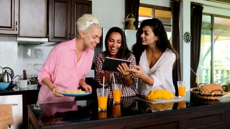 Mädchen-Gruppe-Einsatz-Tablet-Computer-sprechen-Clink-Saft-kochen-Frühstück-Frauen-modernes-Haus-innen-Küche-Studio