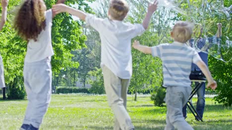 Professional-Performer-Blowing-Large-Bubbles-for-Kids-in-Park