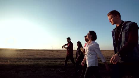 Grupo-de-cinco-personas-caminando-a-lo-largo-de-camino-de-tierra