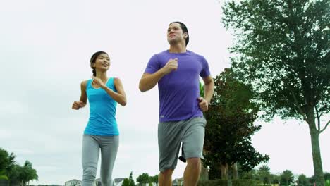 Young-Ethnic-male-female-keeping-fit-jogging-outdoors