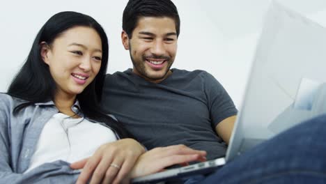 Young-Ethnic-couple-relaxing-social-media-wireless-laptop