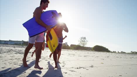 Multi-ethnic-males-and-females-jogging-with-bodyboards