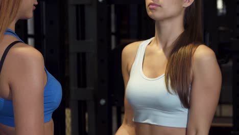 Cropped-shot-of-a-professional-fitness-coach-helping-her-female-client-at-the-gym