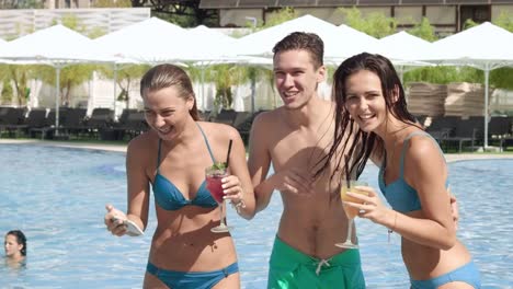 Three-friends-having-fun-and-making-selfie-near-the-pool