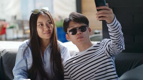 Pareja-asiática-teniendo-Selfie-en-terraza-al-aire-libre