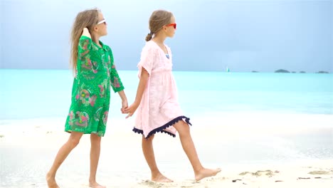 Adorable-niña-con-un-montón-de-diversión-en-la-playa-tropical-tocando-juntos-fondo-turquesa-agua-y-azul-el-cielo