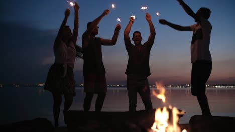 Junge-Menschen-mit-Wunderkerzen-tanzen-in-der-Nacht