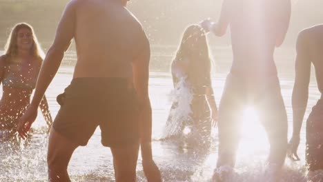 Junge-Erwachsene-Freunde-im-Urlaub-Spaß-im-See-plantschen