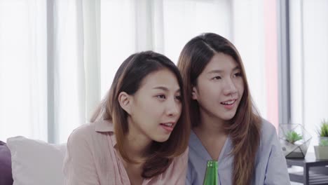 Grupo-de-amigos-las-mujeres-asiáticas-fanático-fanáticos-viendo-partido-de-fútbol-en-televisión-celebrando-gol-en-sofá-gritando-emocionado-y-extasiado-en-la-expresión-de-la-cara-feliz-loco-con-cerveza.