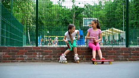 Zwei-kaukasischen-Kinder-sagen,-Geheimnisse,-lachen-und-trinken-im-Park,-im-Freien.