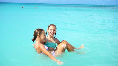 Glückliche-kleine-Mädchen-Schwimmen-im-Meer-während-der-Sommerferien