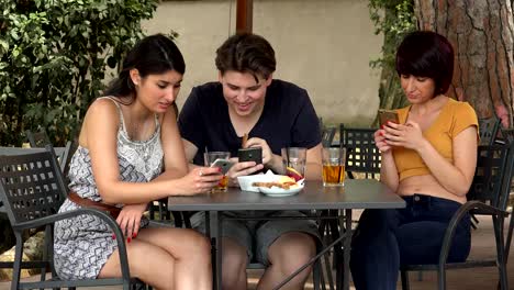 three-friends-at-the-bar-with-smartphones