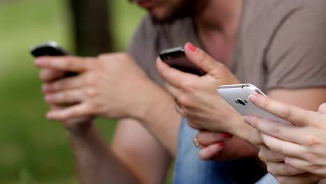 Close-Up-Of-Hands-Texting-On-Smartphone-In-The-park