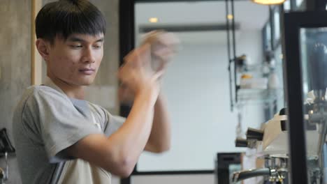 Junge-asiatische-Barista-schüttelt-einen-Shaker-im-Café-in-Zeitlupe