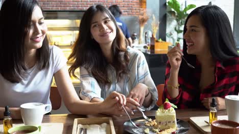 Friends-group-of-three-Asian-female--enjoying-a-strawberry-cake-and-having-a-conversation-at-cafe-and-restaurant