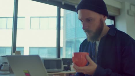 Man-drinks-coffee-while-working-in-the-startup-office