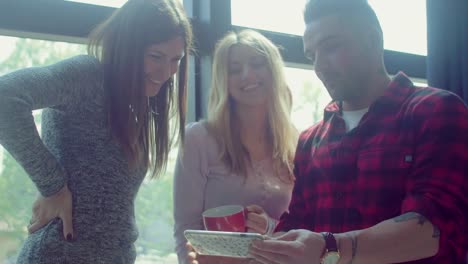 Colleagues-in-the-startup-office-watching-stuff-on-smartphone-during-a-coffee-break