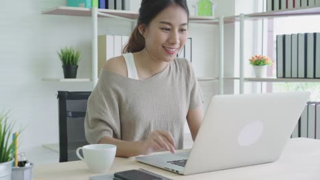 Attractive-young-asian-woman-smiling-positive-and-drinking-coffee-break-feeling-relax-and-calm-at-home-office.