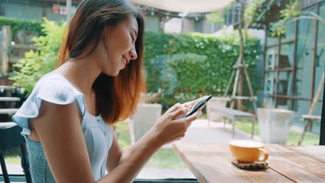 Female-blogger-photographing-coffee-cup-in-cafe-with-her-phone.-A-young-woman-taking-photo-of-coffee-tea-on-smartphone,-photographing-meal-with-mobile-camera.