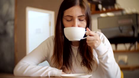 Linda-mujer-en-una-cafetería-tomando-café,-selectiva-focus