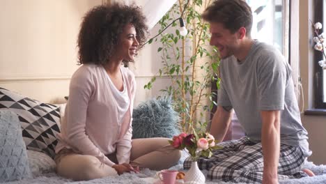 Happy-couple-talking-while-having-breakast-in-bed