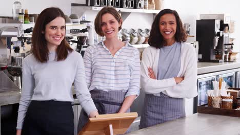 Female-business-partners-behind-the-counter-at-their-cafe