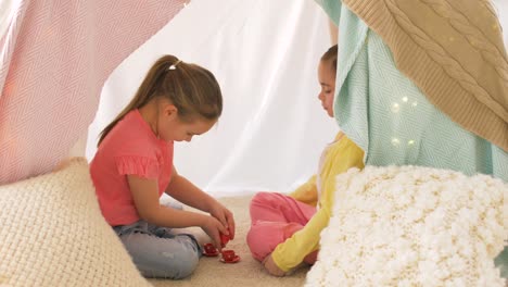 chicas-felices-en-los-niños-de-la-tienda-juego-de-té-en-su-casa