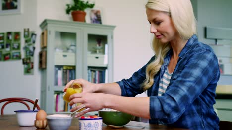 Schöne-blonde-Frau-gießen-und-Orangensaft-trinken