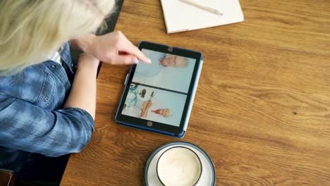 Attractive-Blond-Woman-Swiping-Through-Family-Album-On-Digital-Tablet