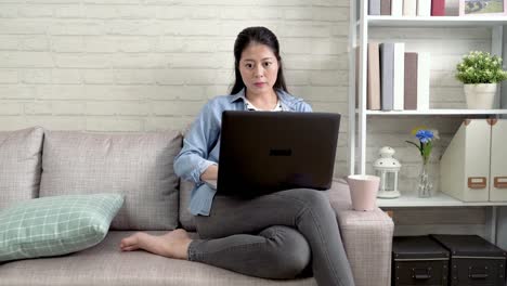 schöne-Frau,-die-Arbeiten-am-Laptop-auf-sofa