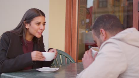 Joven-pareja-disfrutando-de-un-café-al-aire-libre,-del-centro-de-la-ciudad-de-café